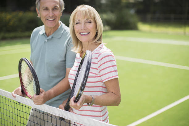 casal sorridente no court de ténis - tennis couple women men imagens e fotografias de stock