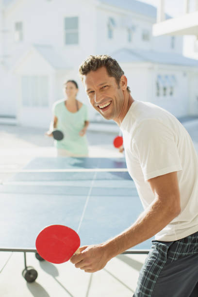 istock Couple playing table tennis outdoors 468840437