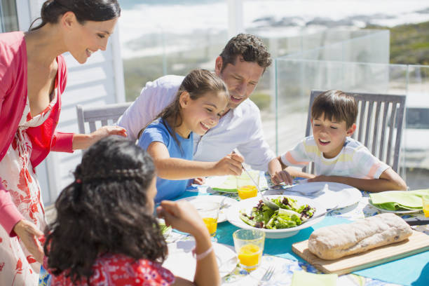 istock Family eating lunch at table on sunny patio 468840463