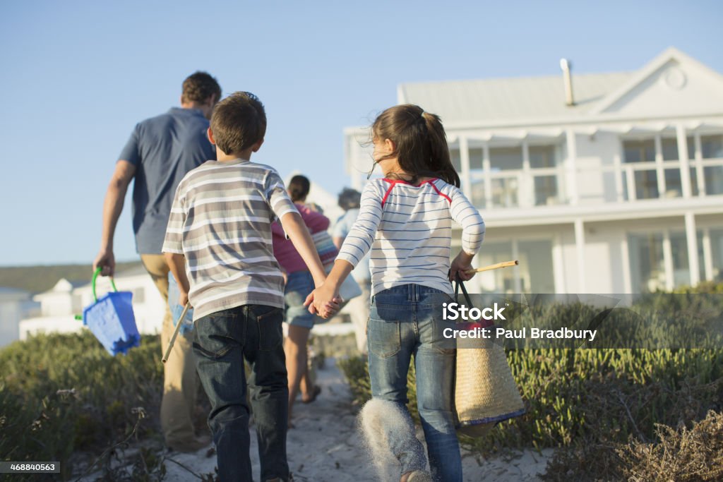 Brother and sister holding hands on beach path  Multi-Generation Family Stock Photo