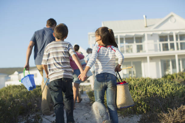 Brother and sister holding hands on beach path  beach house stock pictures, royalty-free photos & images