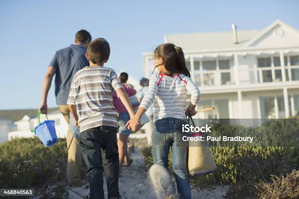 Brother And Sister Holding Hands On Beach Path Stock Photo - Download Image Now - Multi-Generation Family, Beach House, Beach