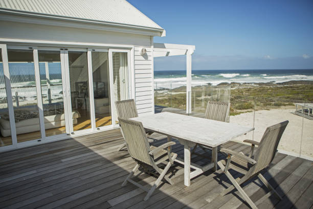 tavolo e sedie su balcone affacciato sulla spiaggia - casa al mare foto e immagini stock