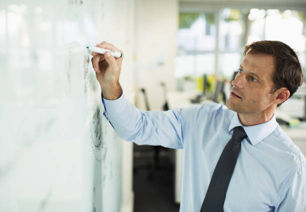 istock Businessman writing on whiteboard in office 468840859
