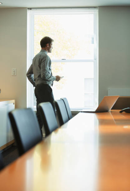 istock Businessman standing at conference room window 468840911