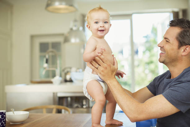 istock Father helping baby walk on table 468841097