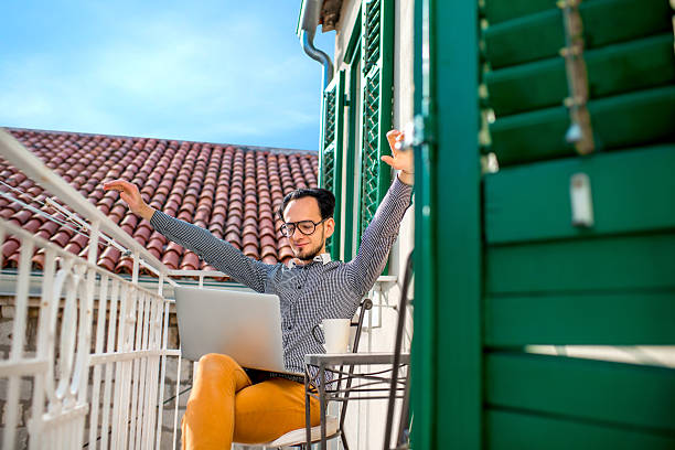 istock Man with laptop on the balcony 468842250