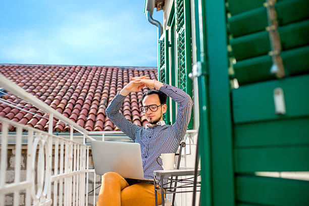 istock Man with laptop on the balcony 468842254