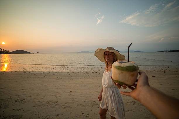 istock Couple on tropical beach sharing a fresh coconut 468842560