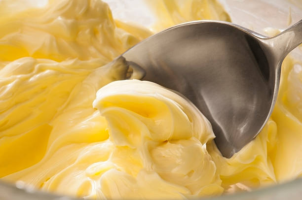 glassa alla crema di burro essere mescolati con un cucchiaio - cake batter foto e immagini stock