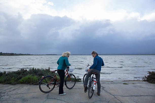 istock Biking couple pause by water edge, look out 468847068