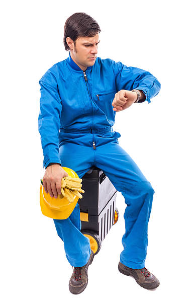 istock Worried construction worker looking at watch with serious expre 468851275