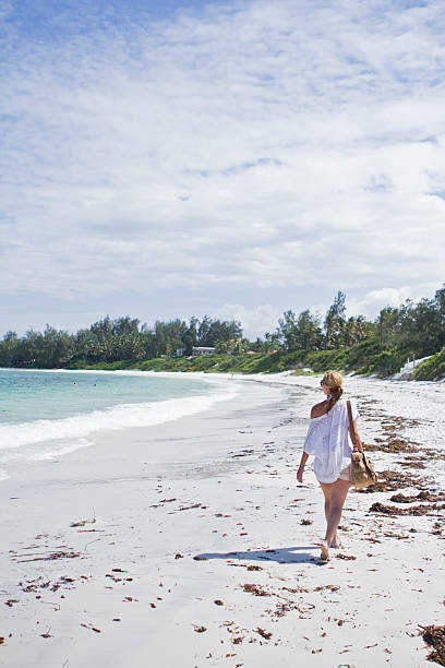 istock Woman walking on white sandy beach in tropical place 468855786
