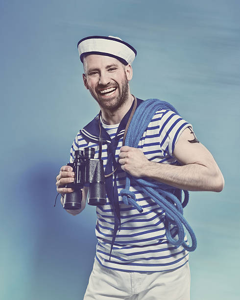 Bearded man in sailor style outfit holding binoculars