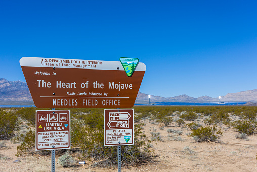 Needles, USA - March 5, 2015: A photo of the Heart of the Mojave sign. The Ivanpah solar energy project can be seen in the background.