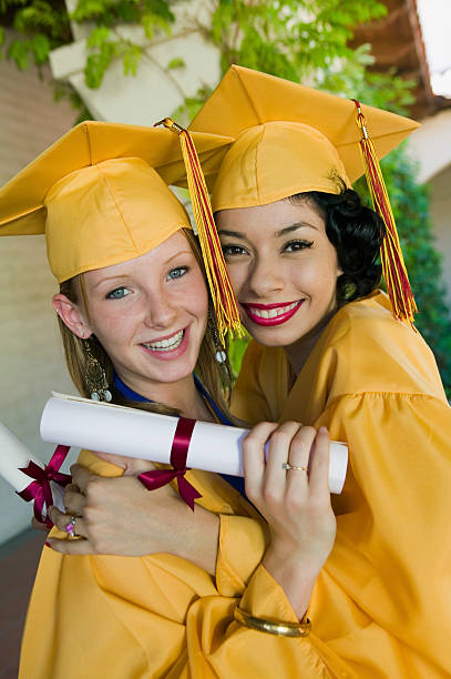 istock Female Students With Diplomas Embracing Each Other In Campus 468860011