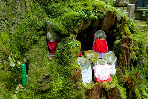 Koyasan, Japan - July 23, 2012: Jizo, bodhisattva statues at Okunoin cemetery. Jizō is popularly venerated as the guardian of unborn, aborted, miscarried, and stillborn babies. At the same time, Jizō serves his/her customary and traditional roles as patron saint of expectant mothers, women in labor, children, firemen, travelers and pilgrims.