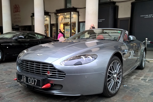 London, United Kingdom, 21st March 2015: an Aston Martin car with 007 number plate on display in Covent Garden piazza, with shops and passers-by in the background 