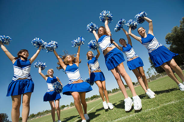 Cheerleading Squad Performing Cheer Cheerleading Squad Performing Cheer cheerleader photos stock pictures, royalty-free photos & images