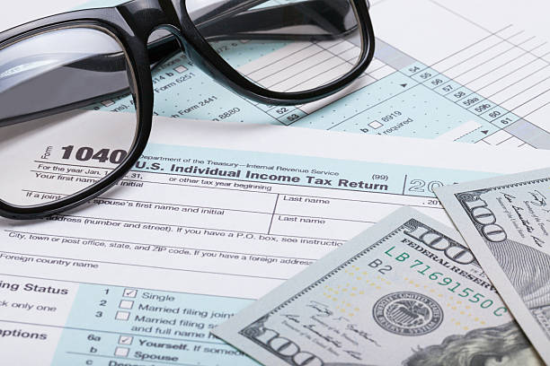 istock US 1040 Tax Form, glasses and dollars - studio shot 468868162