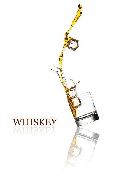 Glass with splashing whisky drink. Isolated on a white background stock photo