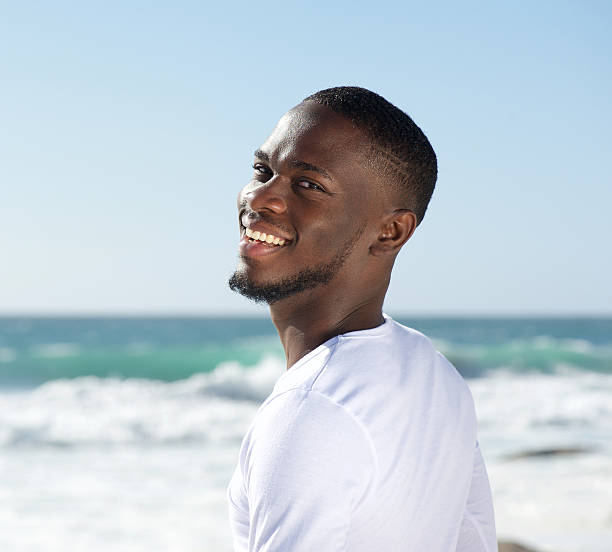 istock Happy smiling cheerful young man at the beach 468874094