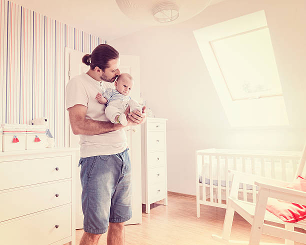 istock Man looking after baby boy, holding son on hands, retro 468874360