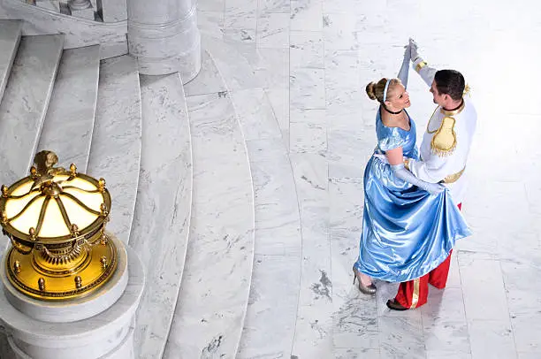 Cinderella and Prince Charming dancing at ball.