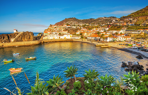 The beautiful fishing village of Camara de Lobos on the portugese Island of Madeira at sunset; in the back the landmark Cabo Girao, the world second highest steep cliff (580 m).
