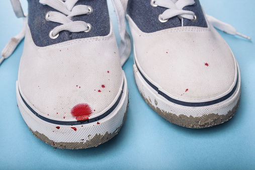 Dirty men's shoes stained with blood spots
