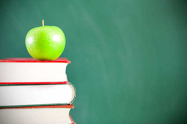 istock Back to school:Green apple  sitting on education books 468880880