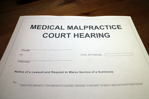 Someone filling out Medical Malpractice Court Hearing.
