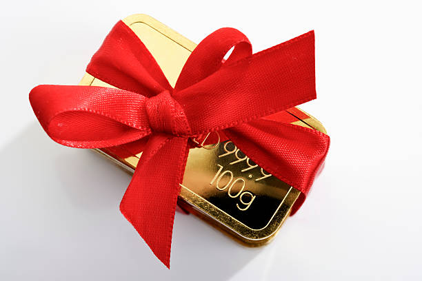 Gold bar with red ribbon stock photo
