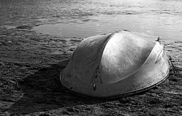 istock Old white and white row boat at lake shore 468881270