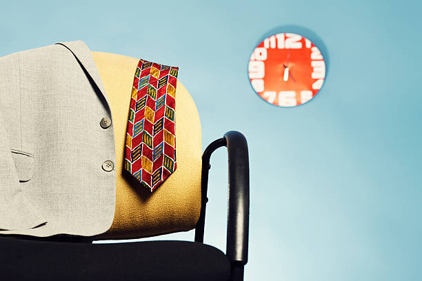 istock Working late! Discarded suit jacket, tie in office with clock 468881399