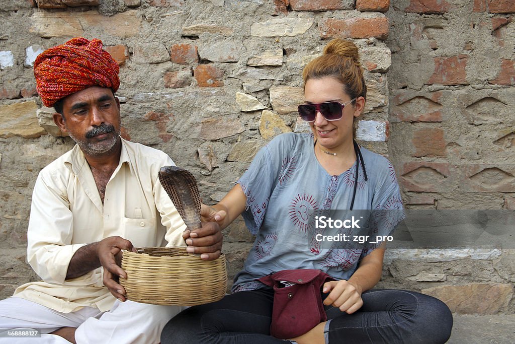 Indian Cobra enchanter and tourist girl Adult Stock Photo