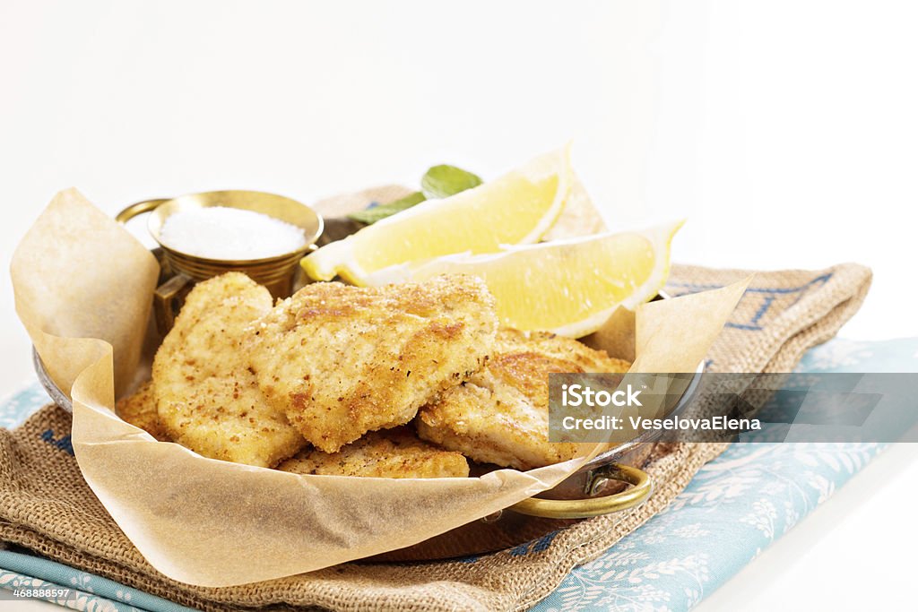 Breaded chicken fillet Breaded chicken fillet with lemons and salt Appetizer Stock Photo