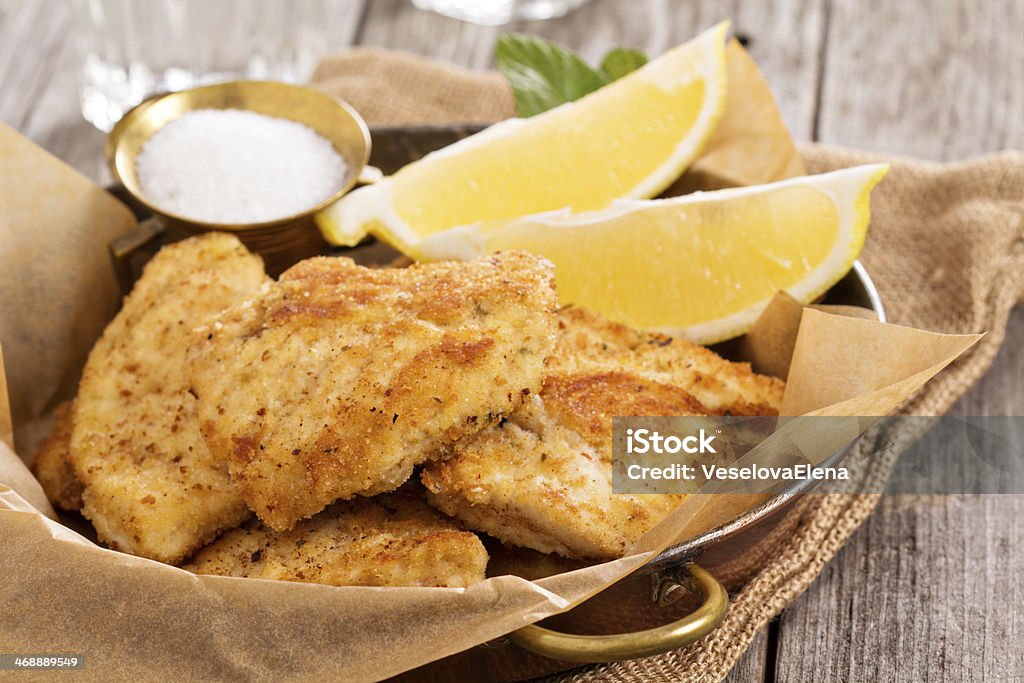 Breaded chicken fillet Breaded chicken fillet with lemons and salt Appetizer Stock Photo