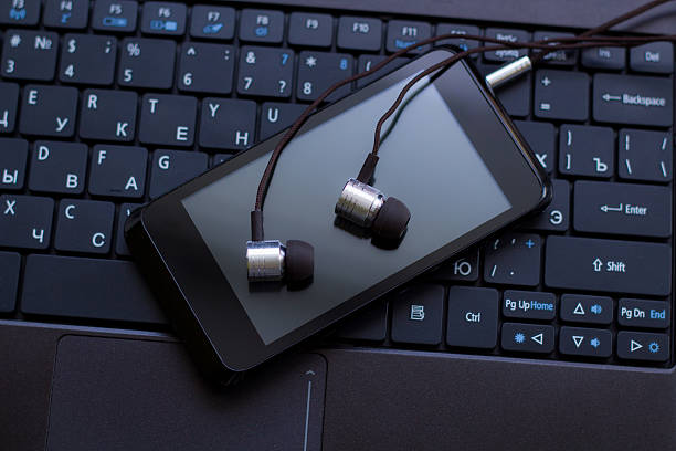 istock Headphones and  cell phone at the keyboard. 468890684