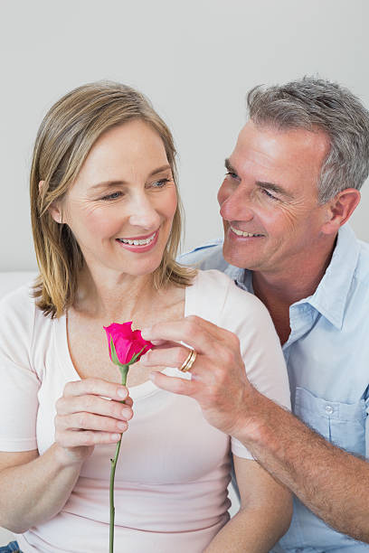 istock Happy romantic couple with a flower at home 468892116