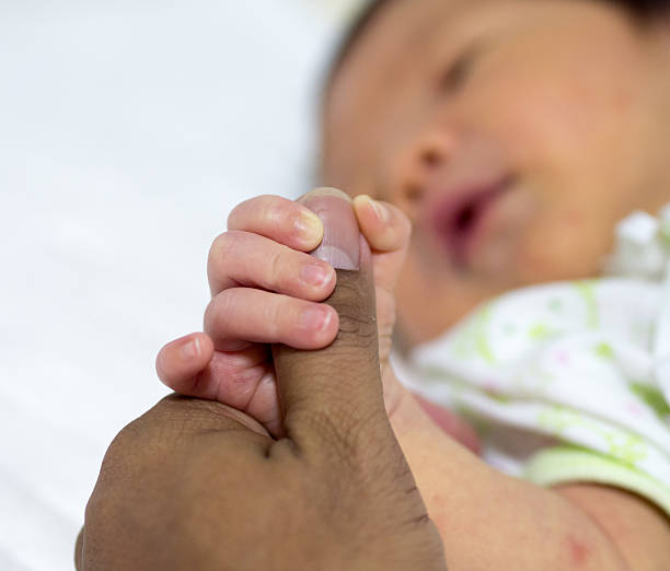 istock Baby holding father thump. 468892236