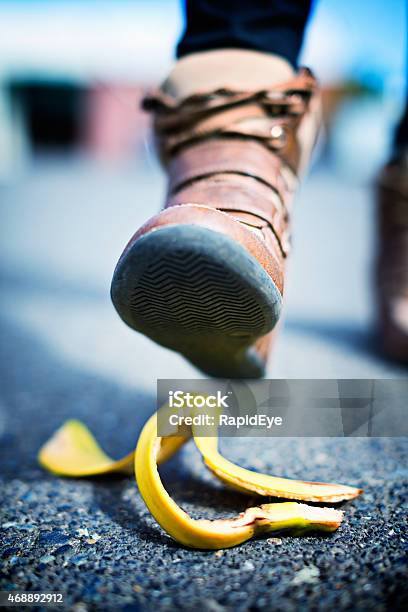 Slippery Situation Booted Foot Aproaching Banana Skin On Street Stock Photo - Download Image Now