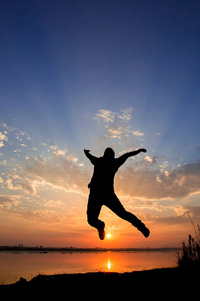 istock Silhouette of a man jumping over sunset background 468895892