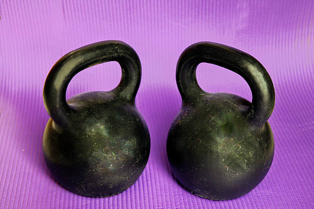 istock Two kettlebells on violet sport mat 468896894