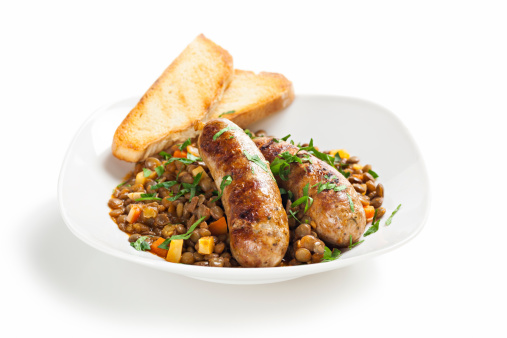 Sausage and lentils dish isolated on white