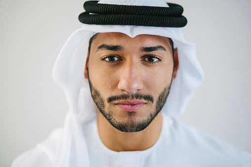 Close up portrait of Emirati businessman wearing traditional clothing - kandura, kaffiyeh and agal. Also known as disdasha.