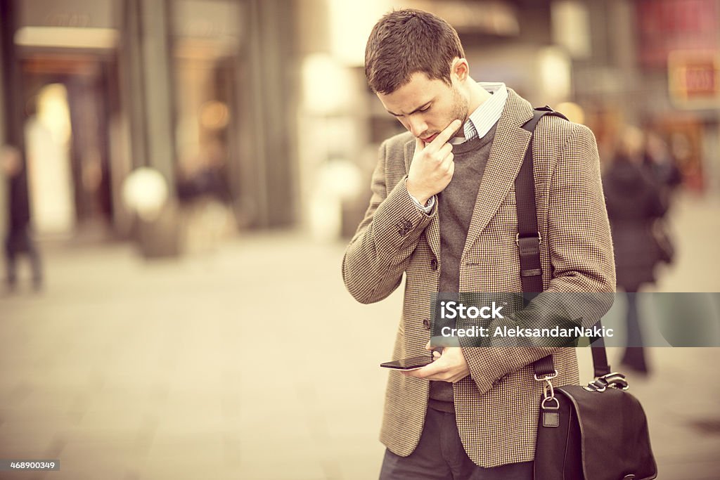 Young man using a smarphone on the street 25-29 Years Stock Photo