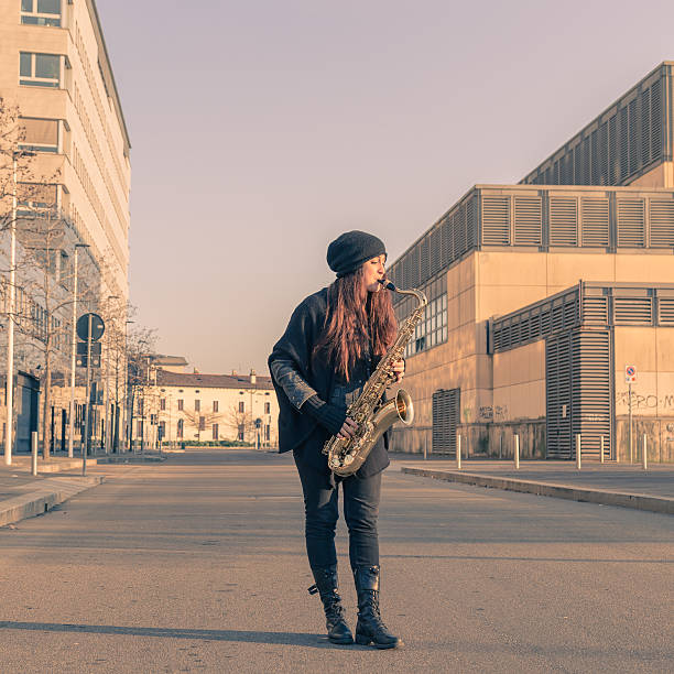 istock Beautiful young woman playing tenor saxophone 468902854