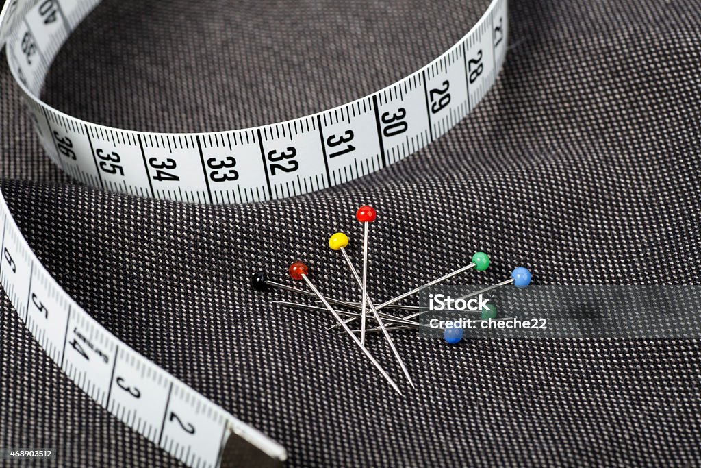 Pins and Measuring Tape Pins and measuring tape on fabric, ready for sewing. 2015 Stock Photo