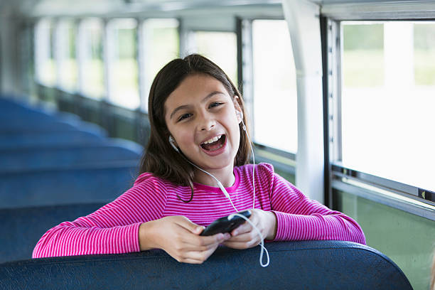 hispanic girl riding school bus - bussing stock-fotos und bilder